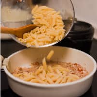 放入煮熟的義⼤利麵、煮麵⽔。 ＊提⽰：⽤煮麵⽔可以協助收汁及增加鹽味。