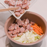 將香腸、紅蘿蔔絲、高麗菜絲鋪在米上，選擇電鍋的煮飯模式