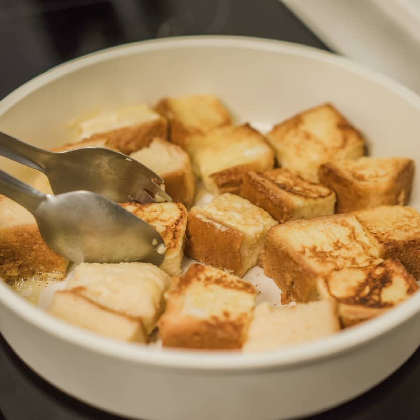 平底鍋放入少量奶油，以小火將吐司煎至金黃色。