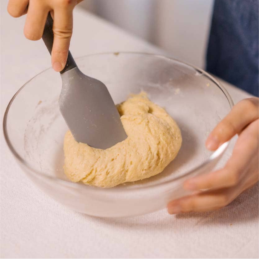 拌至成團後，撒上少許麵粉避免沾黏，並分成6等份（⼀個⼤約48公克），搓圓以保鮮膜封住放置30分鐘。