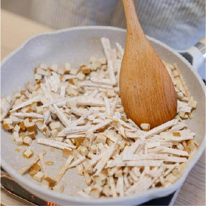 將芋頭及豆乾丁以麻油煎至金黃色後,再加入香菇爆香拌炒。