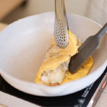撒上黑胡椒後，捲起蛋餅再慢慢煎至定型。