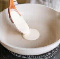 將低筋麵粉、水和味醂拌匀後，舀一杓麵糊倒入熱鍋中鋪圓。