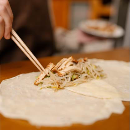 攤開雨張春捲皮,依序放入炒高麗菜、炒豆芽菜、炒滷百頁豆腐絲。