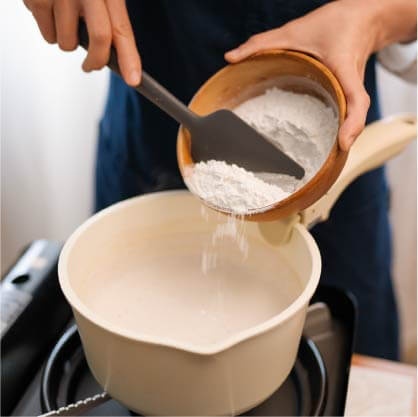 加入地瓜粉、在來米粉和糖粉拌均後，開火煮滾再切至小火快速攪拌成糊。