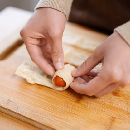 將豆皮攤開後切成1/4等分，捲起小番茄後叉起成串。