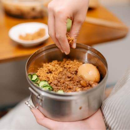 將肉燥放至糯米飯上,放上滷鴨蛋、滷花生和小黃瓜,撒上旗魚鬆、放上香菜。
