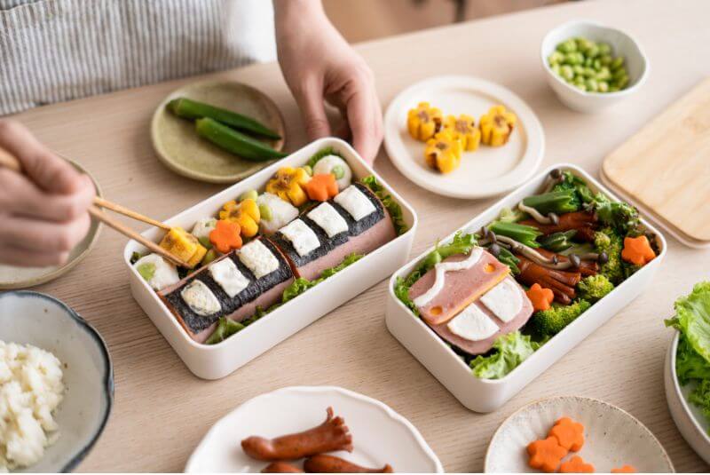 以美乃滋輔助將火腿等食材固定黏上，並裝飾便當。