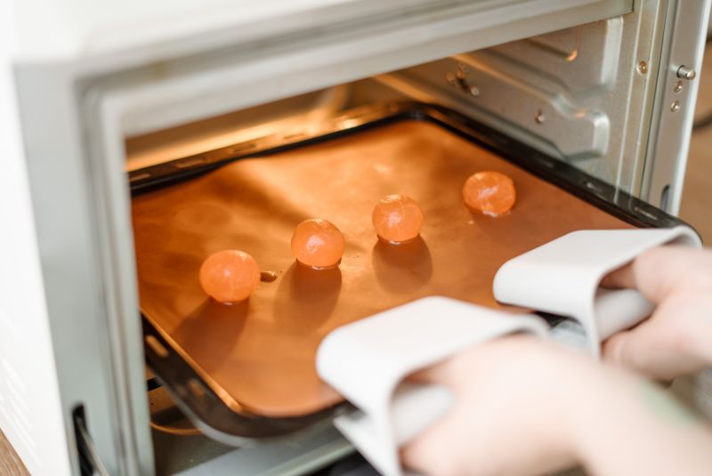 鹹蛋黃浸泡米酒2分鐘後取出，放入預熱烤箱以160度烘烤約8分鐘，對半分切備用。