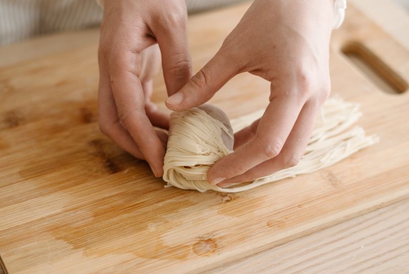 將麵線過熱水軟化後，將芋丸包裹起來。