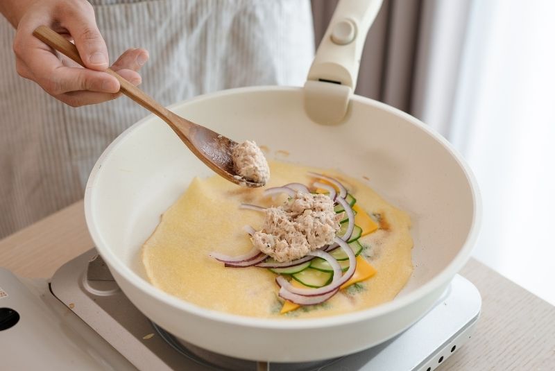 關火後，放入起司、小黃瓜片、紫洋蔥絲，以及新東陽水煮鮪魚片做成的鮪魚沙拉